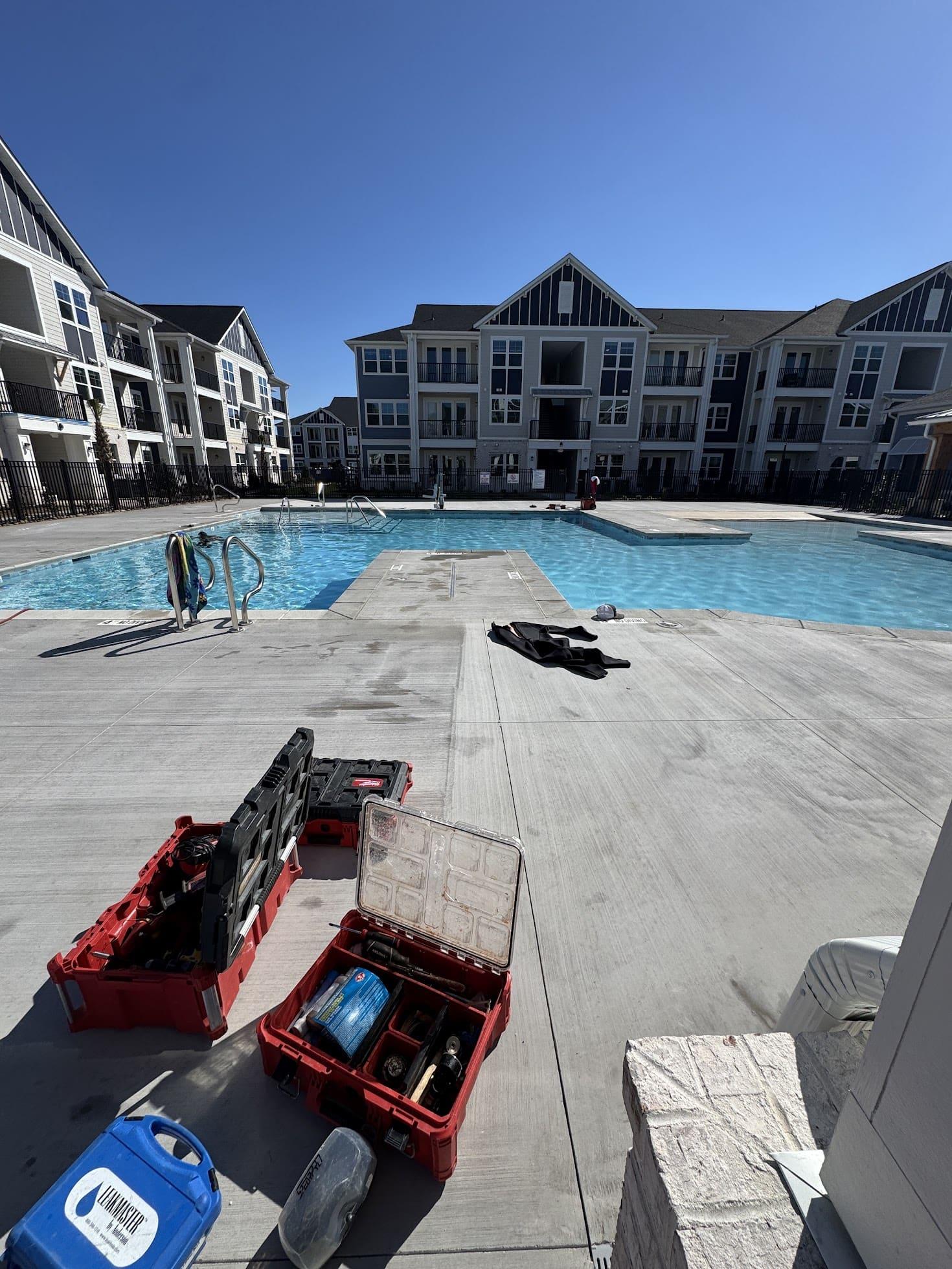 Leak-detection equipment set up beside a commercial apartment-community pool.