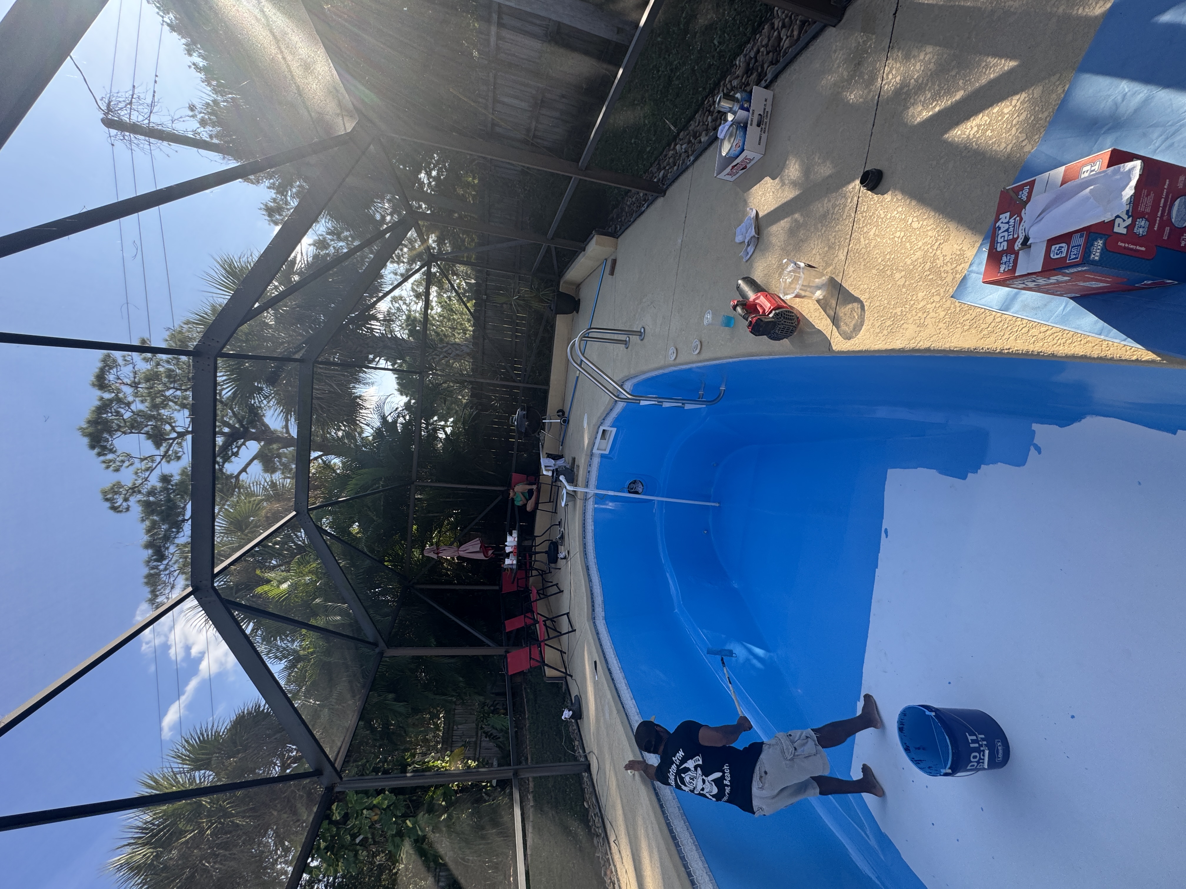 Technician applying fresh pool resurface after leak repair